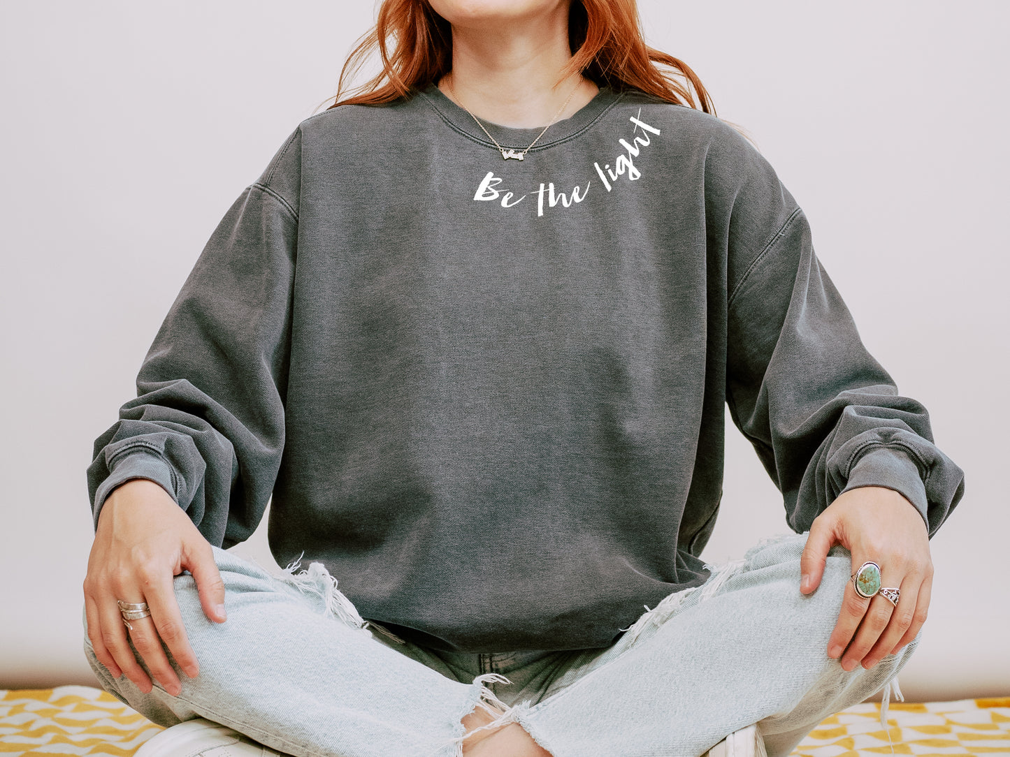BE THE LIGHT AROUND THE NECK UNISEX SWEATSHIRT